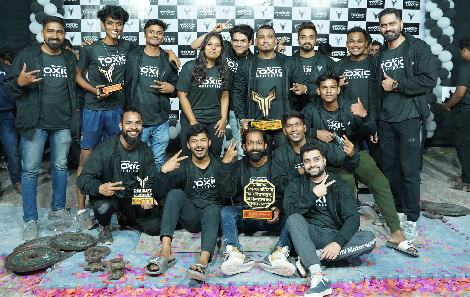 The Toxic Fitness team showcasing custom-designed apparel after a championship event, representing unity, style, and brand identity